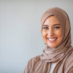 testimonials women 1 Portrait of a young woman in traditional Muslim clothing, smiling. Beautiful woman headshot looking at camera and wearing a hijab. Arabian woman with happy smile. Strict formal outfit and elegant appearance. Islamic fashion.